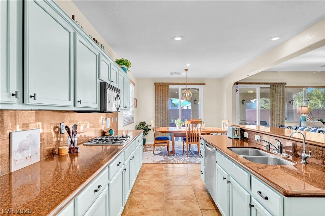 9928 Tradition Creek Avenue, Las Vegas, NV 89149 Culinary delights await in this light-filled kitchen, featuring ample counter space and seamless flow to the dining area.