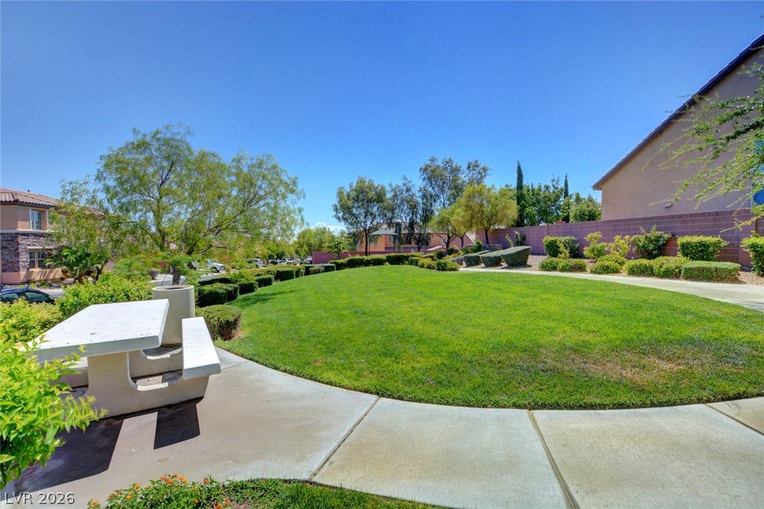 9928 Tradition Creek Avenue, Las Vegas, NV 89149 Green landscaping and a picnic table offer a perfect outdoor relaxation spot.