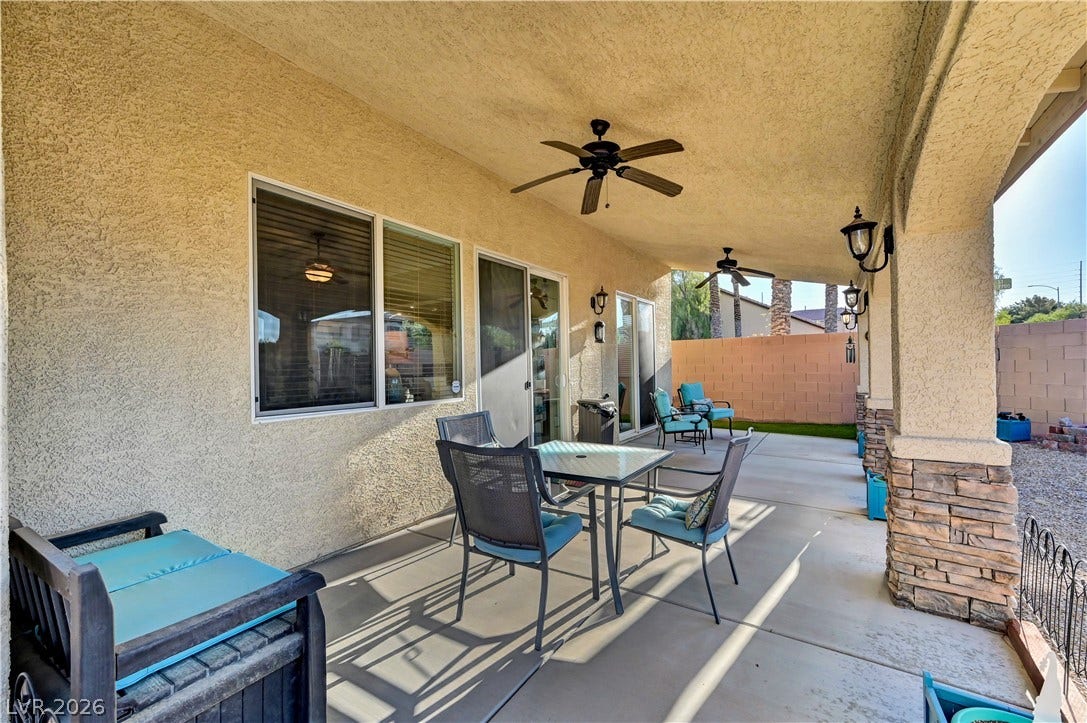 9928 Tradition Creek Avenue, Las Vegas, NV 89149 An inviting covered patio features dual ceiling fans and provides ample space for outdoor dining and relaxation.