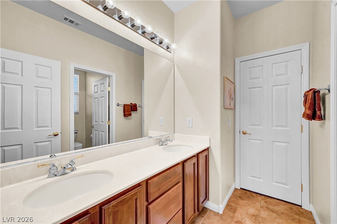 9928 Tradition Creek Avenue, Las Vegas, NV 89149 Double vanity with ample counter space and storage offers convenience in this well-appointed bathroom.