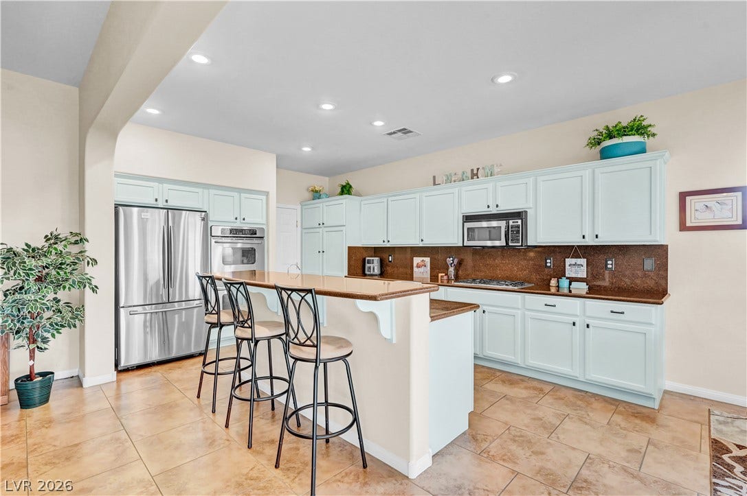 9928 Tradition Creek Avenue, Las Vegas, NV 89149 A well-lit kitchen with generous countertop space and light cabinetry invites culinary endeavors.