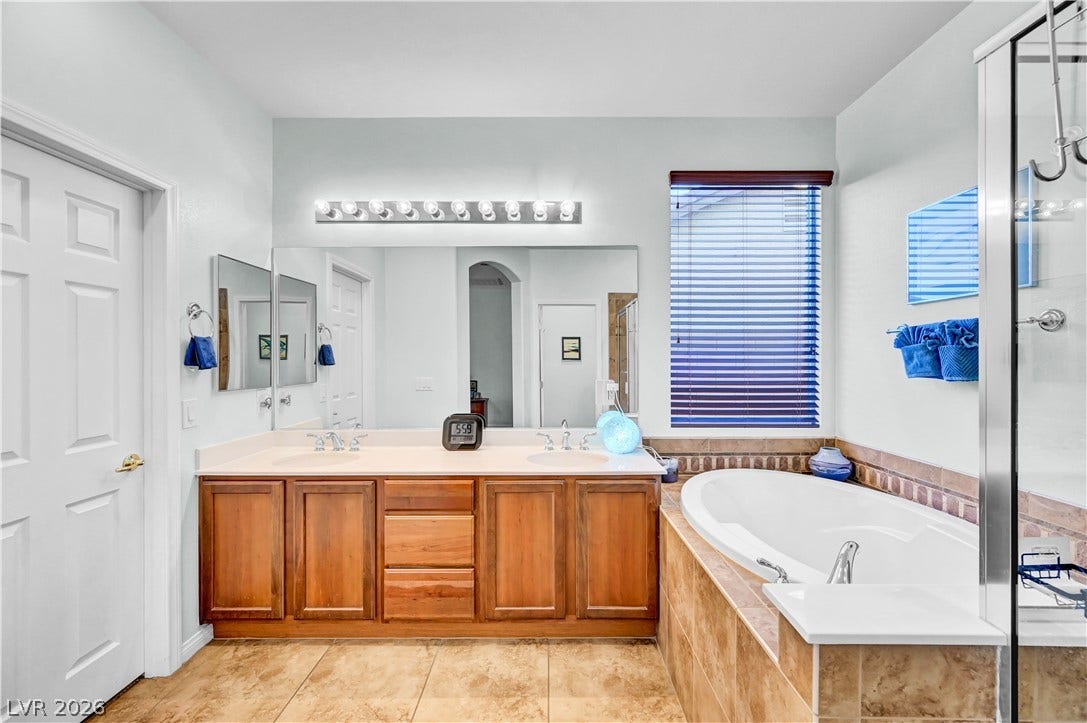 9928 Tradition Creek Avenue, Las Vegas, NV 89149 Relax in this tranquil bathroom featuring a soaking tub and double vanity with ample storage.