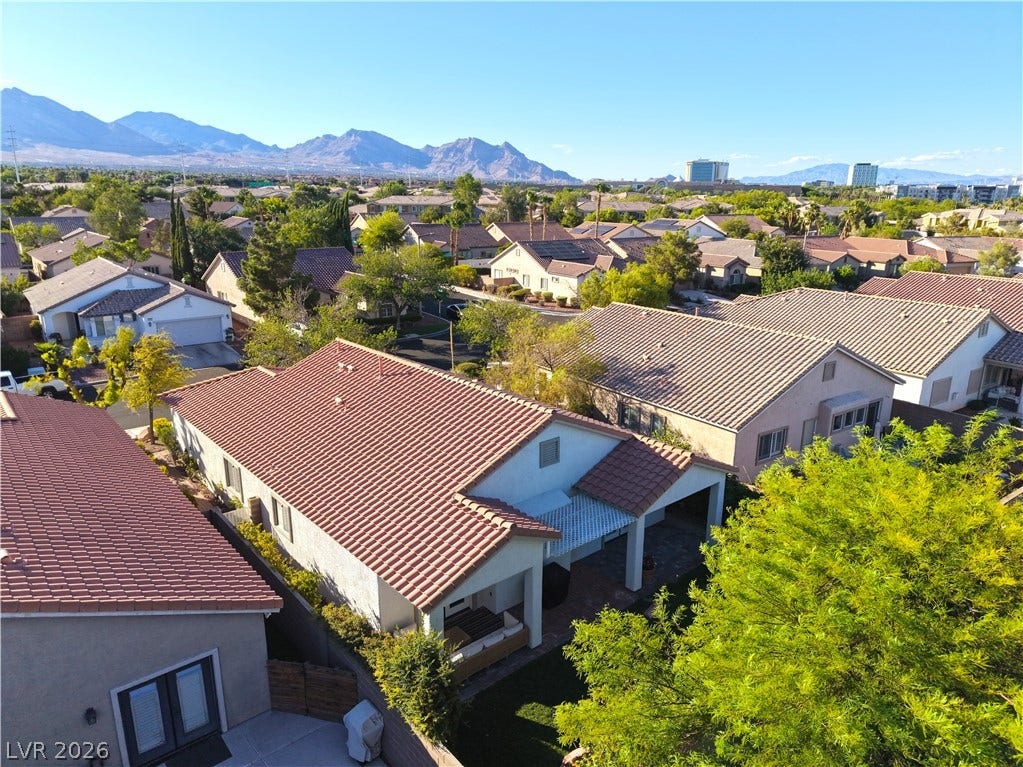 An aerial perspective reveals a serene neighborhood nestled against a majestic mountain backdrop.