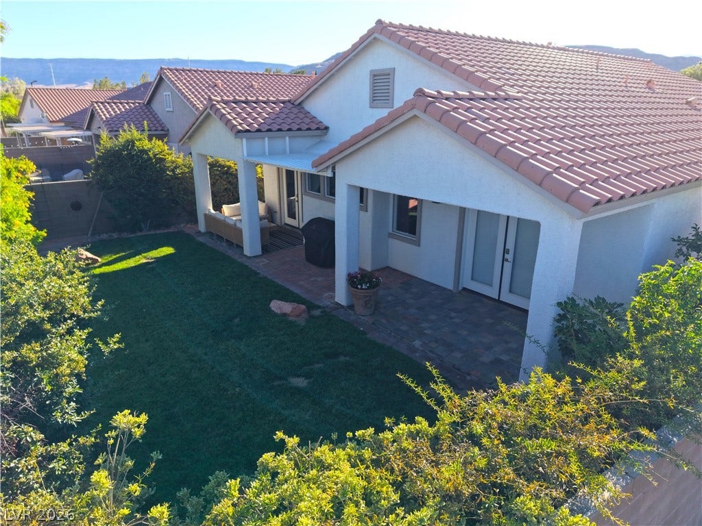 A well-kept backyard with a verdant lawn and covered patios offers serene outdoor living.