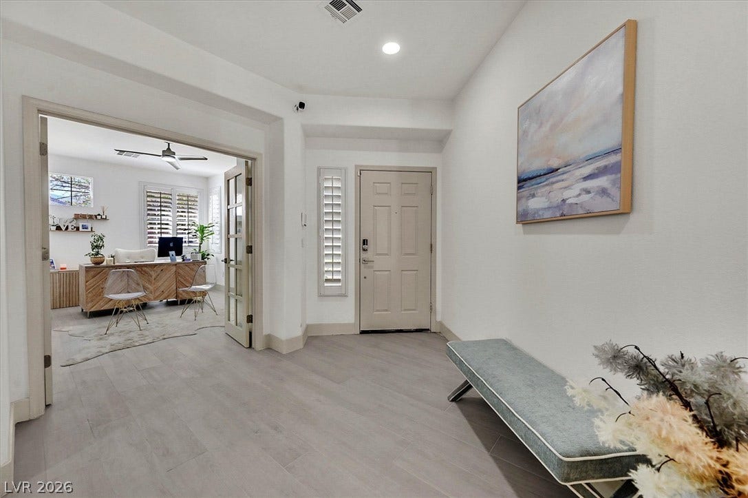 A welcoming entryway with cool-toned tile flooring flows into a bright, versatile office space.