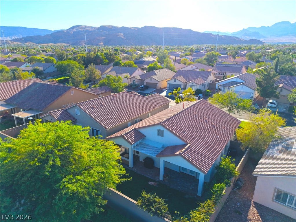 An aerial perspective reveals a serene suburban neighborhood nestled against a majestic mountain range.