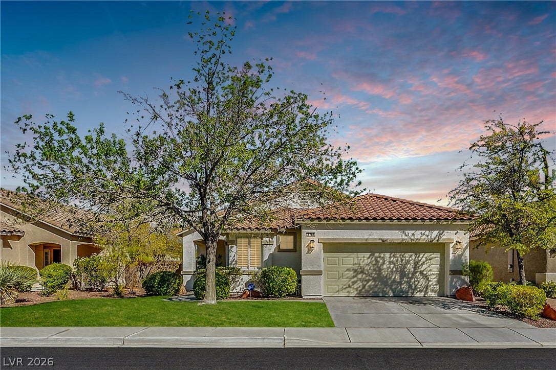 A terracotta-tiled roof crowns this residence, featuring an attached garage and a neatly landscaped front yard.