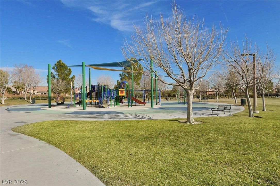 A vibrant neighborhood park offers children a colorful playground and ample green space for outdoor activities.