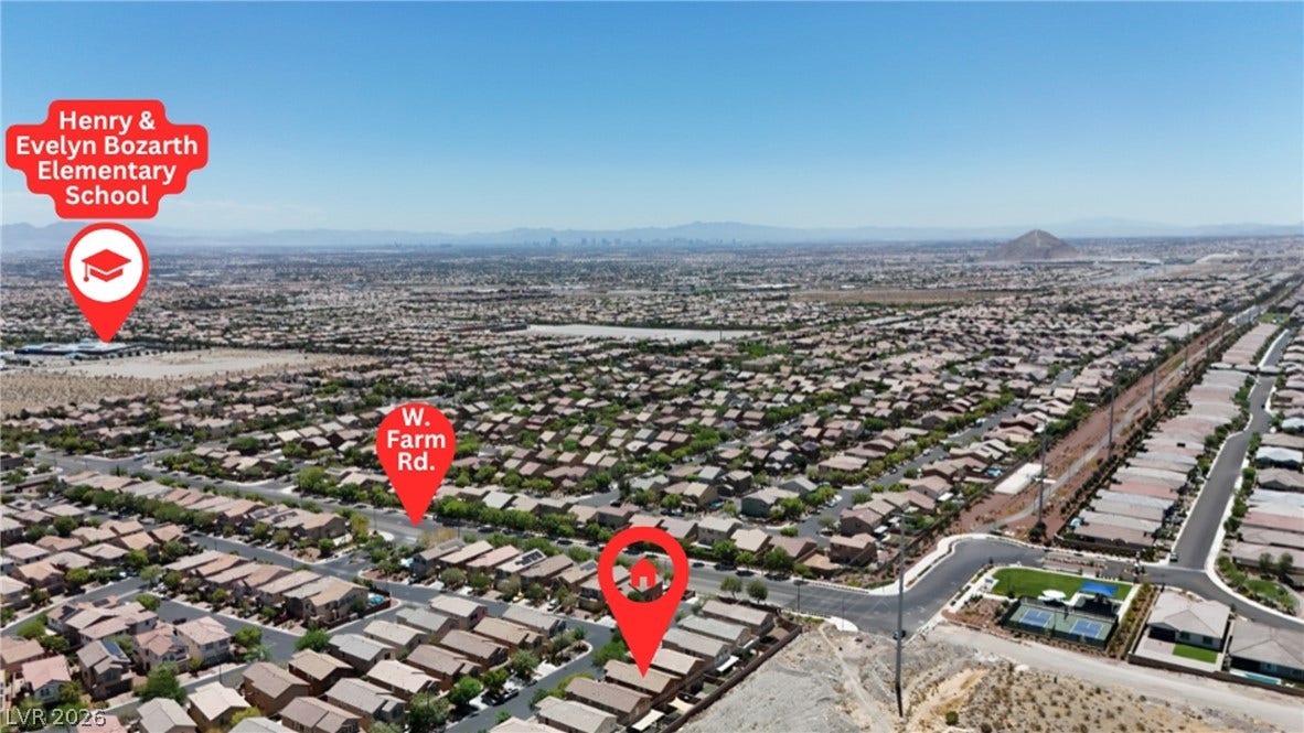 An aerial perspective showcases a vibrant neighborhood, complete with a school, community courts, and panoramic desert views.