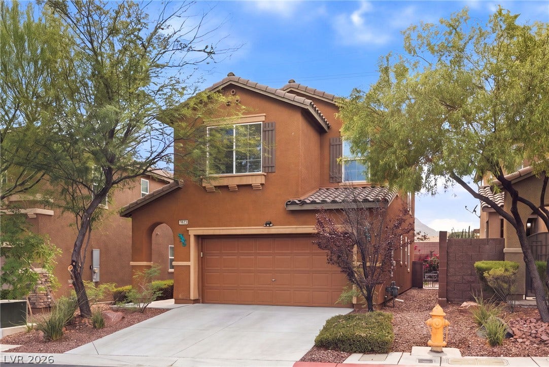 An inviting front facade features an attached garage and desert-friendly landscaping.