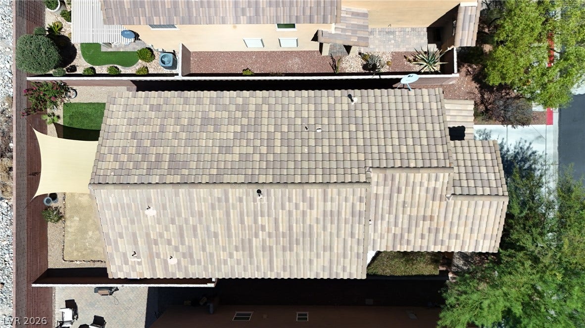 An aerial perspective reveals a neatly tiled roof and a vibrant green backyard, perfect for outdoor living.