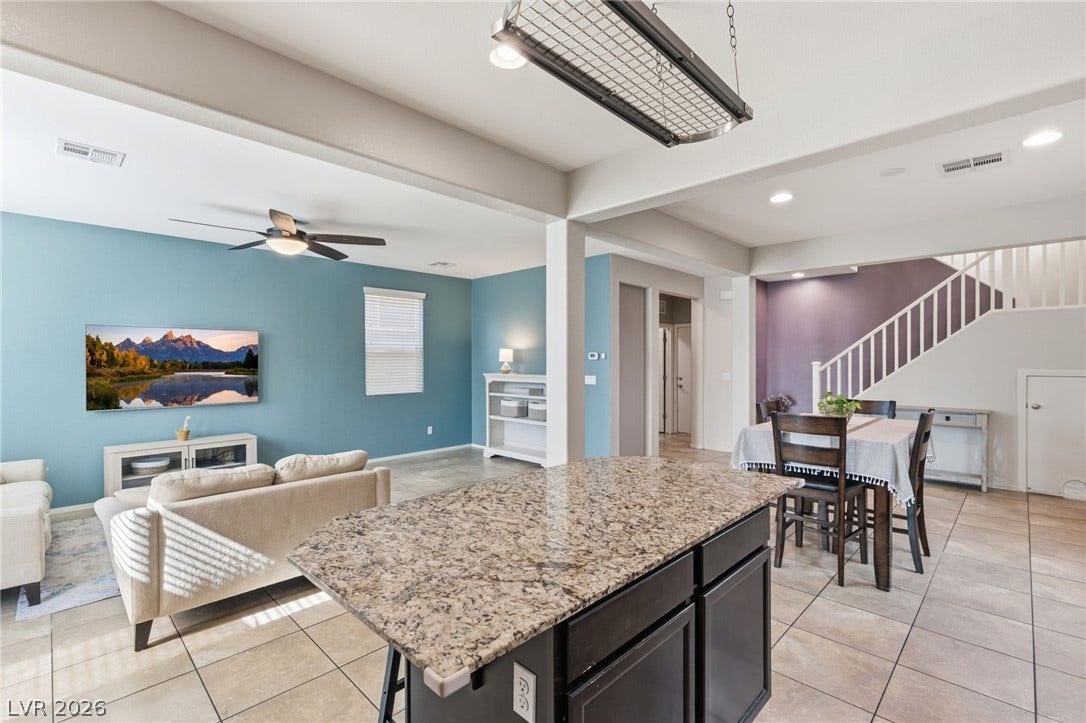 A well-lit open-concept living space with a kitchen island, dining area, and living room.