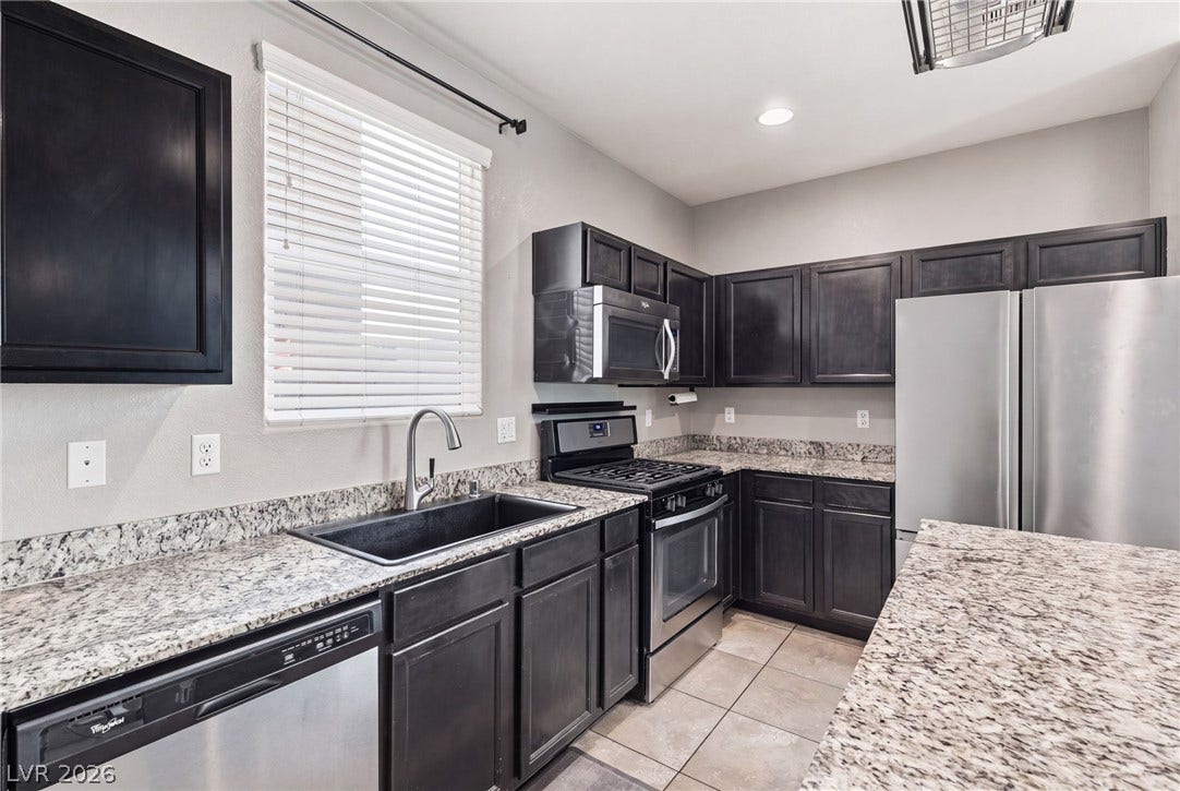 Modern kitchen with granite countertops and stainless steel appliances awaits culinary adventures.