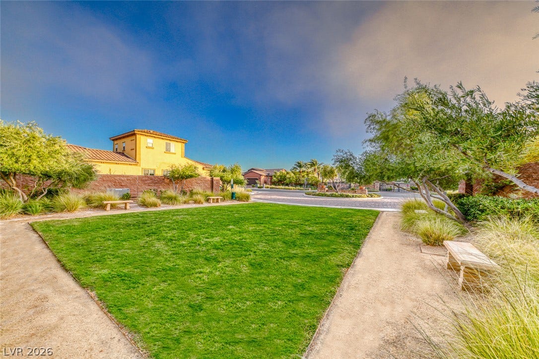 70 Portezza Drive, Henderson, NV 89011 A vibrant green lawn and inviting pathway offer a tranquil common area for community enjoyment.