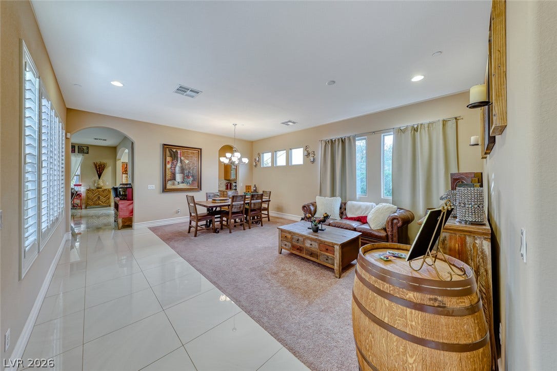70 Portezza Drive, Henderson, NV 89011 An inviting open-concept layout connects living and dining spaces, featuring both carpeted and tiled flooring.