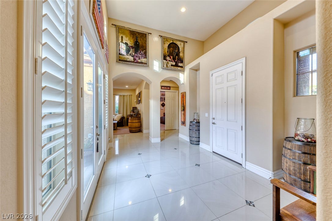 70 Portezza Drive, Henderson, NV 89011 A graceful entrance foyer welcomes with high vaulted ceilings and gleaming tiled flooring.
