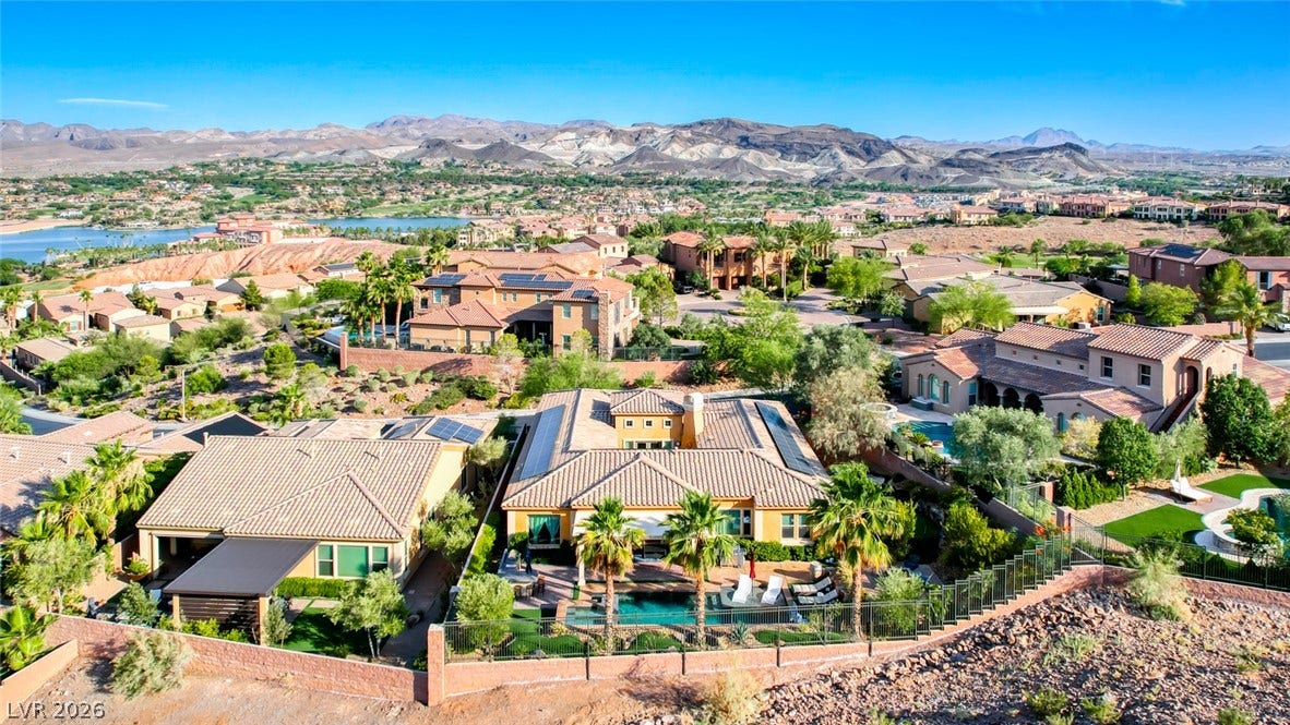 70 Portezza Drive, Henderson, NV 89011 An aerial perspective reveals a luxury residence nestled amidst verdant landscaping, complete with a private pool and panoramic mountain vistas.