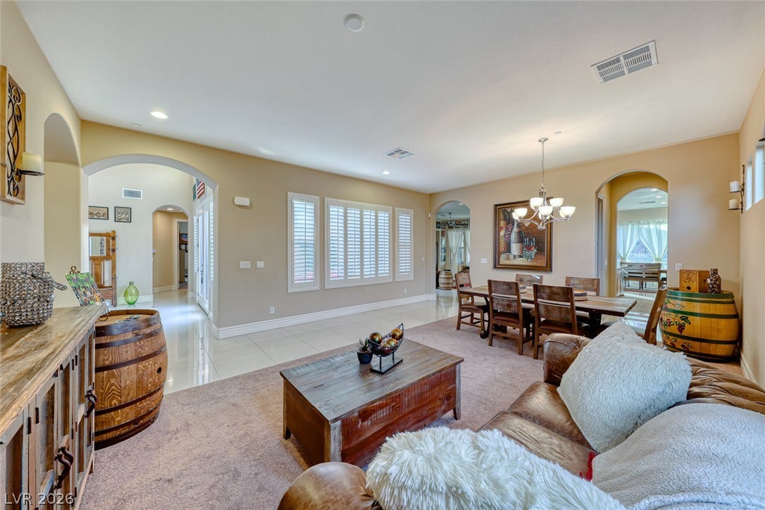70 Portezza Drive, Henderson, NV 89011 Archways connect versatile spaces, flowing from a sun-filled living area to an inviting dining space.