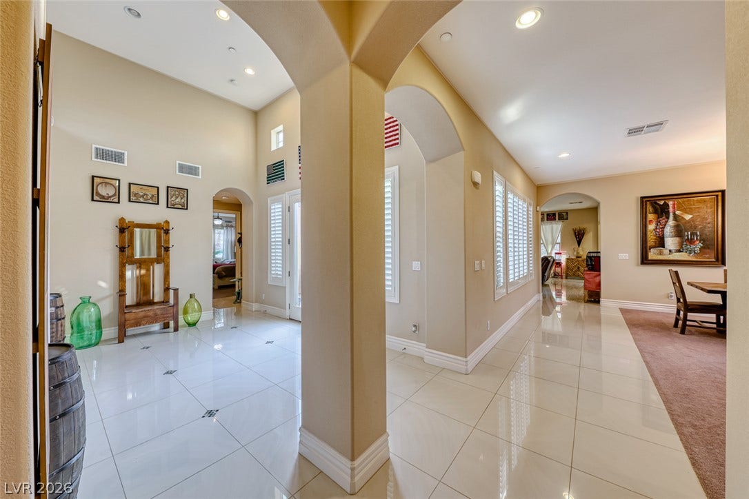 70 Portezza Drive, Henderson, NV 89011 Enter into an elegant foyer, featuring soaring ceilings, pristine tile flooring, and architectural arches that define sophisticated living.