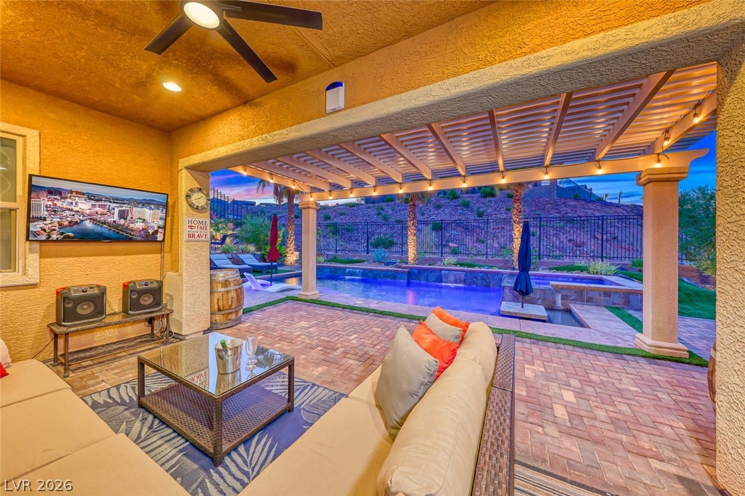 70 Portezza Drive, Henderson, NV 89011 An inviting outdoor living space features a covered patio with recessed lighting and a ceiling fan, overlooking a private pool and spa.
