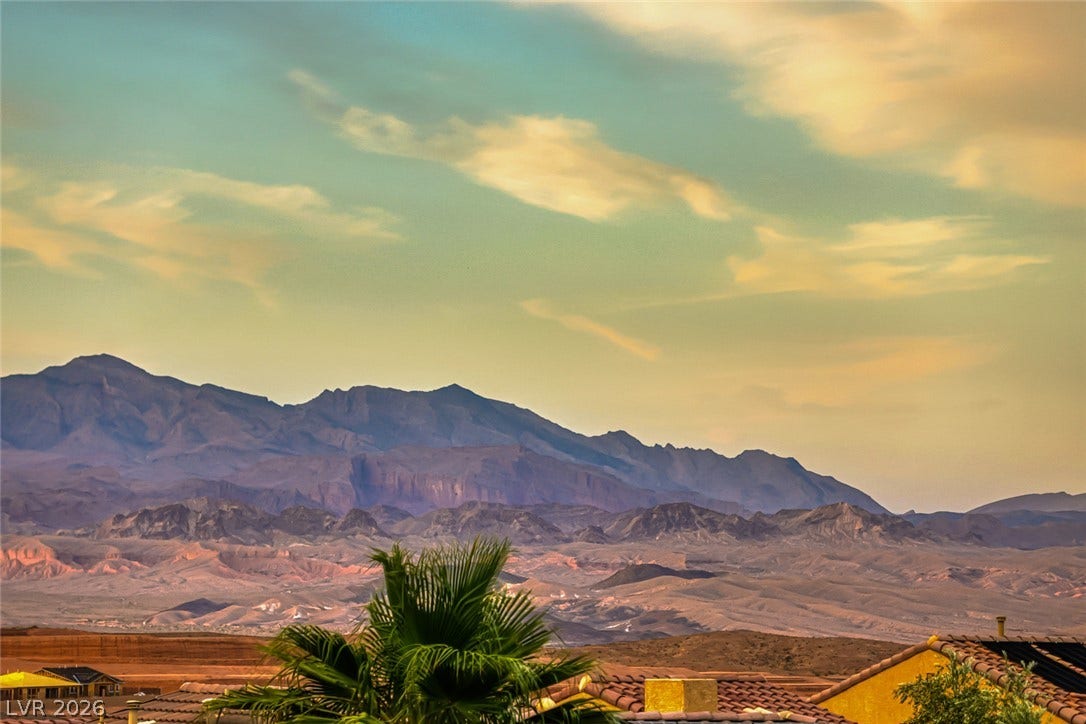 70 Portezza Drive, Henderson, NV 89011 Dramatic mountain range vistas unfold beneath a vast, colorful desert sky.