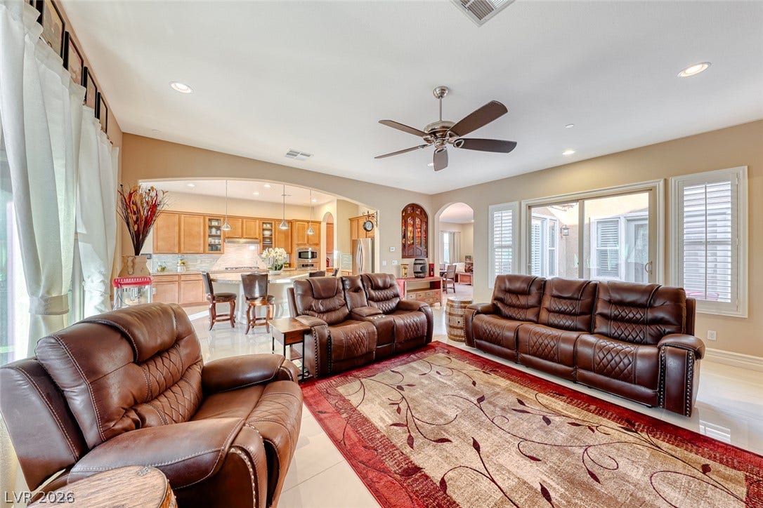 70 Portezza Drive, Henderson, NV 89011 An inviting open-concept living space features a spacious kitchen and a light-filled common area with sliding glass doors.