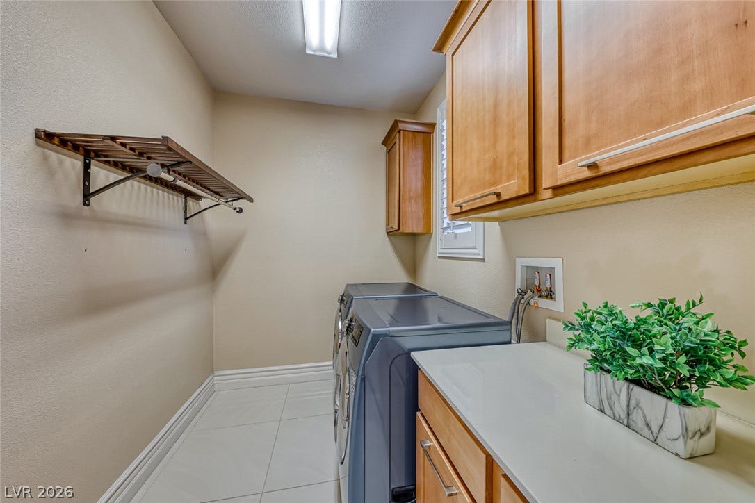 70 Portezza Drive, Henderson, NV 89011 Functional laundry space featuring durable tile flooring and convenient built-in cabinetry for organized storage.