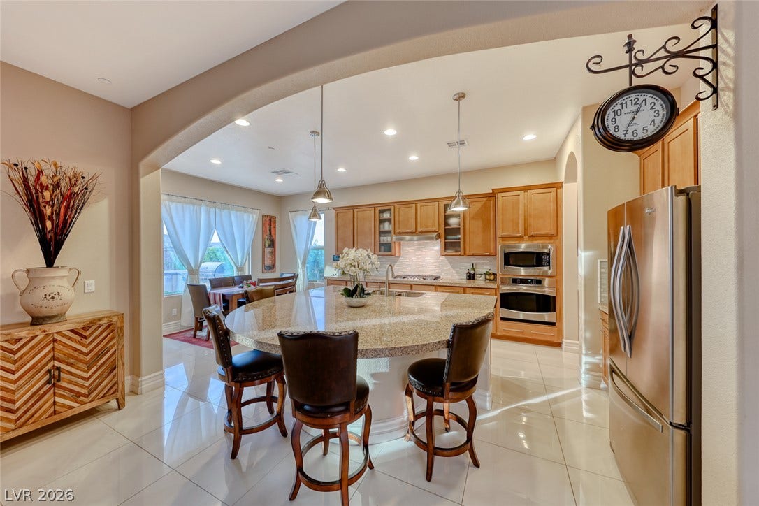 70 Portezza Drive, Henderson, NV 89011 An open-concept kitchen features a spacious island with bar seating and seamless flow into the dining area.