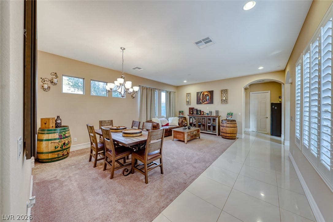 70 Portezza Drive, Henderson, NV 89011 An inviting open-concept area combines a relaxed dining space with a comfortable living room, featuring tasteful recessed lighting.