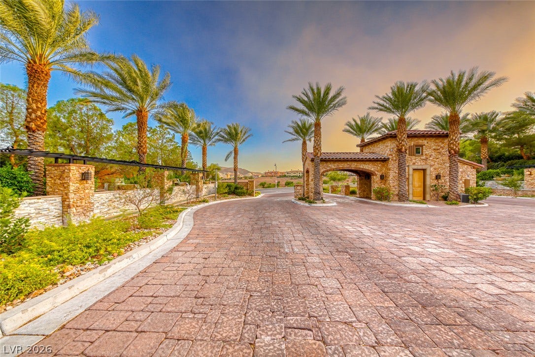70 Portezza Drive, Henderson, NV 89011 Secure, gated entry welcomes you home, flanked by mature palm trees and natural stone accents.