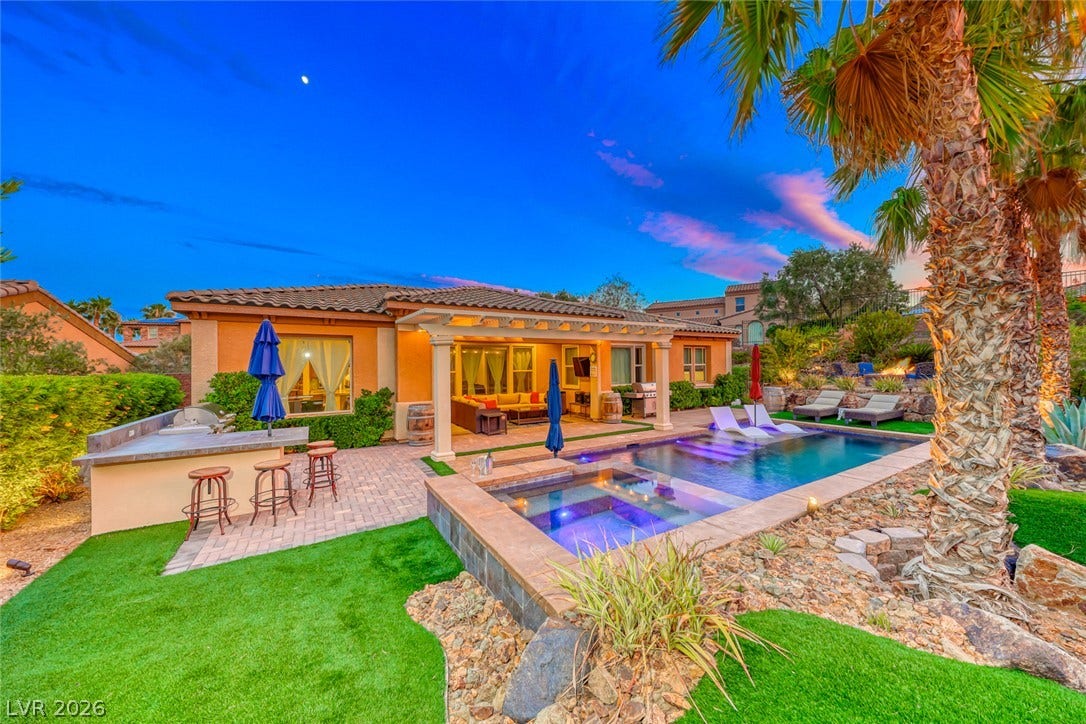 70 Portezza Drive, Henderson, NV 89011 An inviting outdoor living space features a sparkling pool and spa, alongside an integrated barbecue area, perfect for entertaining.