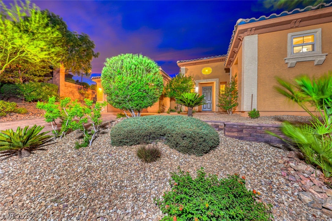 70 Portezza Drive, Henderson, NV 89011 A desert-friendly landscape with decorative rocks and verdant plantings frames the home's inviting entryway.