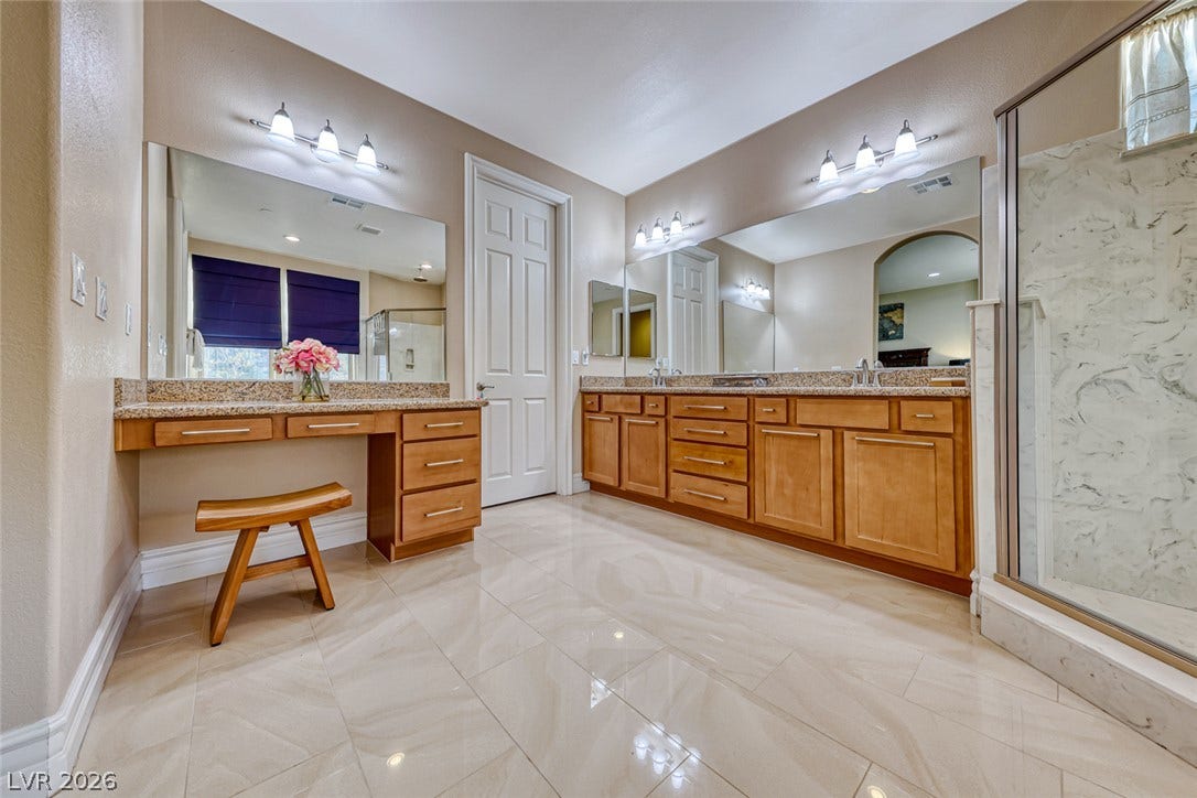 70 Portezza Drive, Henderson, NV 89011 Marble-tiled floors and dual vanities define this generous, well-appointed primary bathroom.