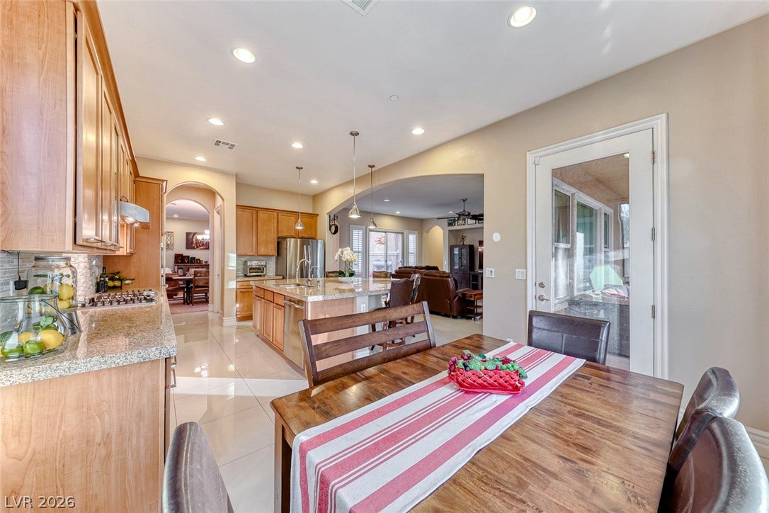 70 Portezza Drive, Henderson, NV 89011 A well-lit dining area flows seamlessly into a gourmet kitchen, perfect for entertaining.