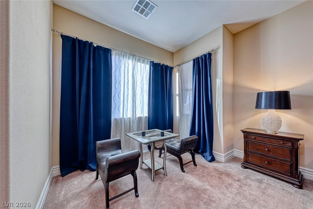 70 Portezza Drive, Henderson, NV 89011 A quiet corner features plush carpeting and elegant window treatments, offering a cozy retreat.