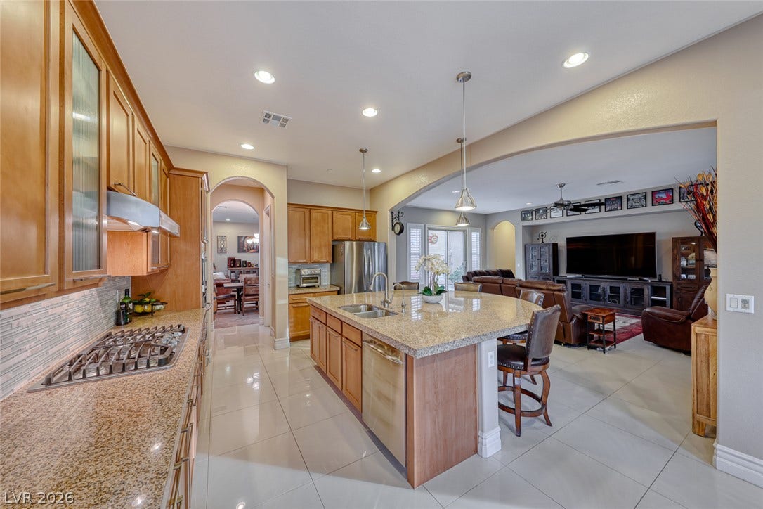 70 Portezza Drive, Henderson, NV 89011 Culinary creativity awaits in this open-concept kitchen, flowing seamlessly into a cozy living area.