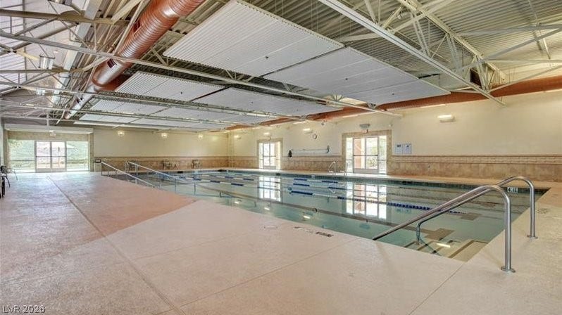 An indoor lap pool, perfect for year-round exercise, features a spacious deck and ample natural light.