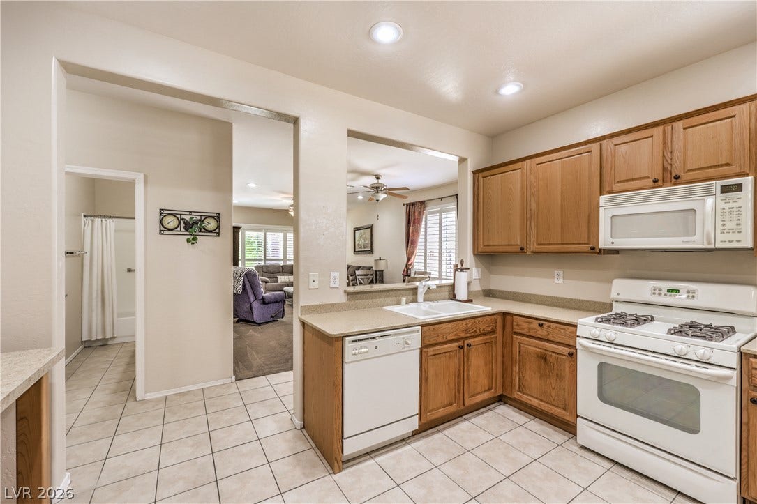 2439 Erastus Drive, Henderson, NV 89044 Kitchen with Upgraded Cabinets, Corian Counters, Recessed Lighting, Pantry, Tile Flooring,Refrigerator, Gas Stove, Dishwasher, andMicrowave