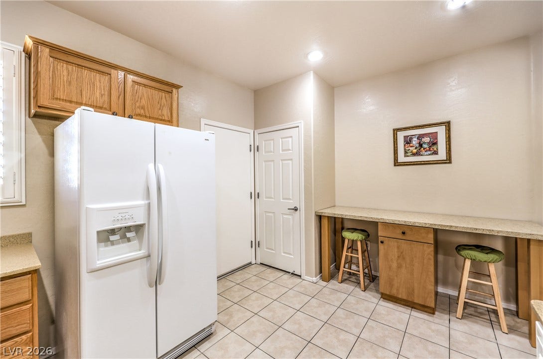 2439 Erastus Drive, Henderson, NV 89044 Kitchen with Upgraded Cabinets, Corian Counters, Recessed Lighting, Pantry, Tile Flooring,Refrigerator, Gas Stove, Dishwasher, andMicrowave