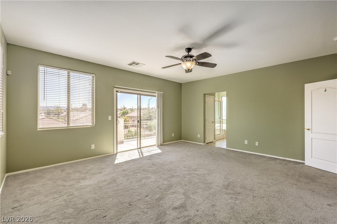 260 Quail Ranch Drive, Henderson, NV 89015 A restful primary bedroom with soft carpeting and balcony access for private outdoor enjoyment.