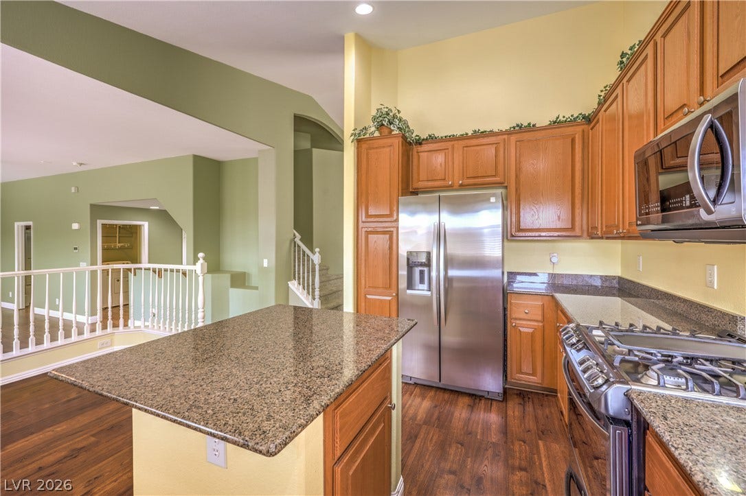 260 Quail Ranch Drive, Henderson, NV 89015 Culinary adventures await in this kitchen featuring abundant wood cabinetry and stone countertops.