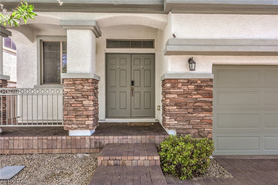260 Quail Ranch Drive, Henderson, NV 89015 An inviting front entry welcomes with double doors, stone veneer accents, and an attached garage.