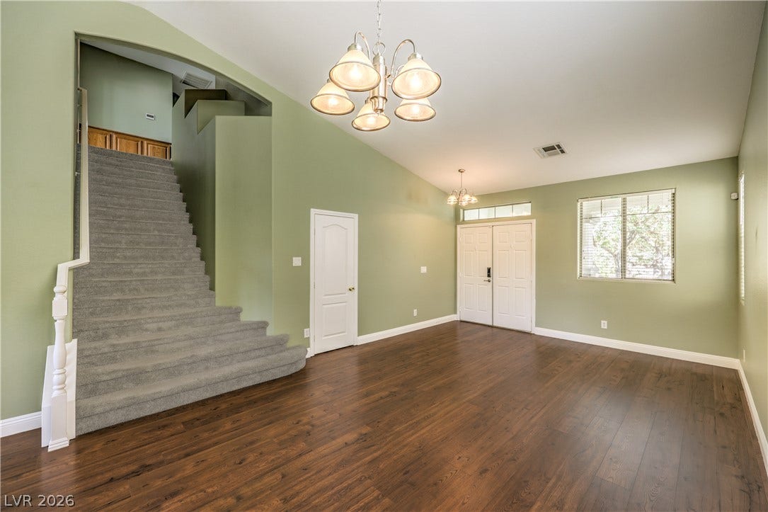 260 Quail Ranch Drive, Henderson, NV 89015 Luminous entry foyer with rich wood flooring and a grand carpeted staircase.