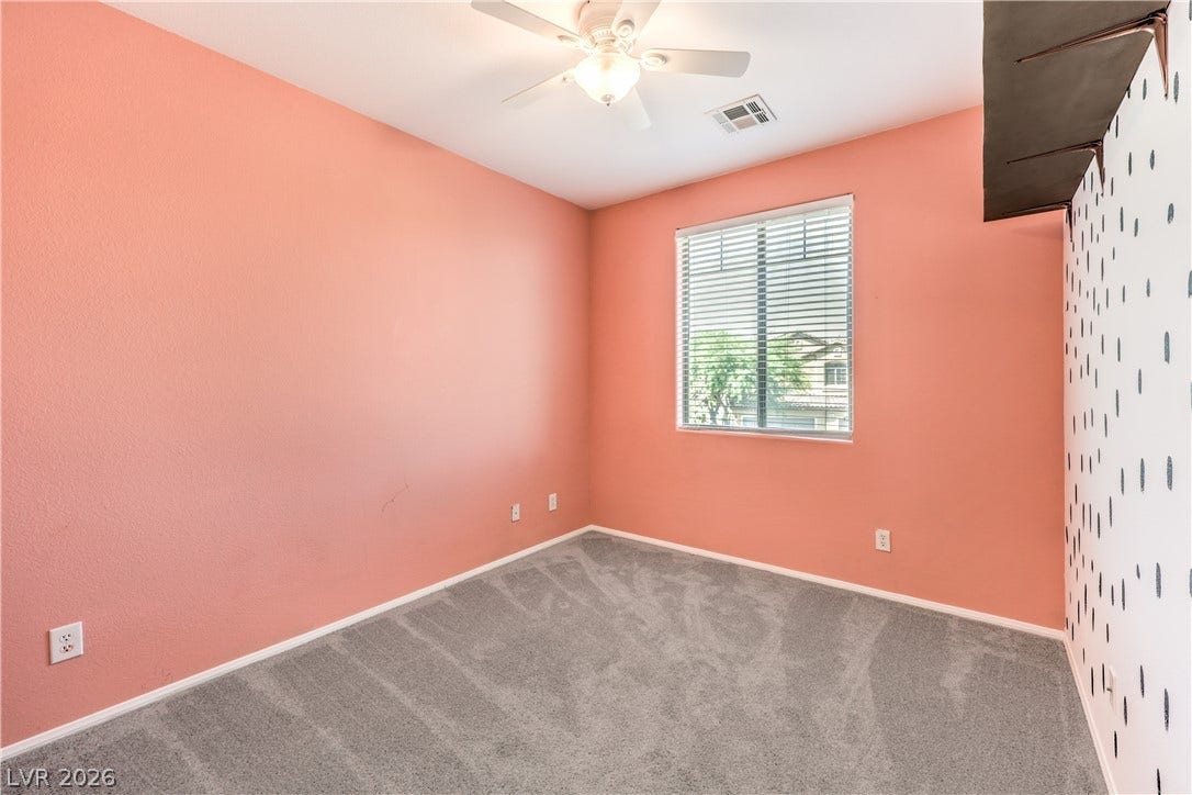 260 Quail Ranch Drive, Henderson, NV 89015 A well-lit room featuring a window with blinds, carpeted flooring, and a ceiling fan.