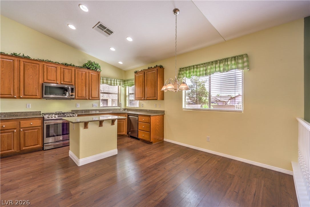 260 Quail Ranch Drive, Henderson, NV 89015 Prepare meals in a well-lit kitchen featuring granite counters and rich wood cabinetry.