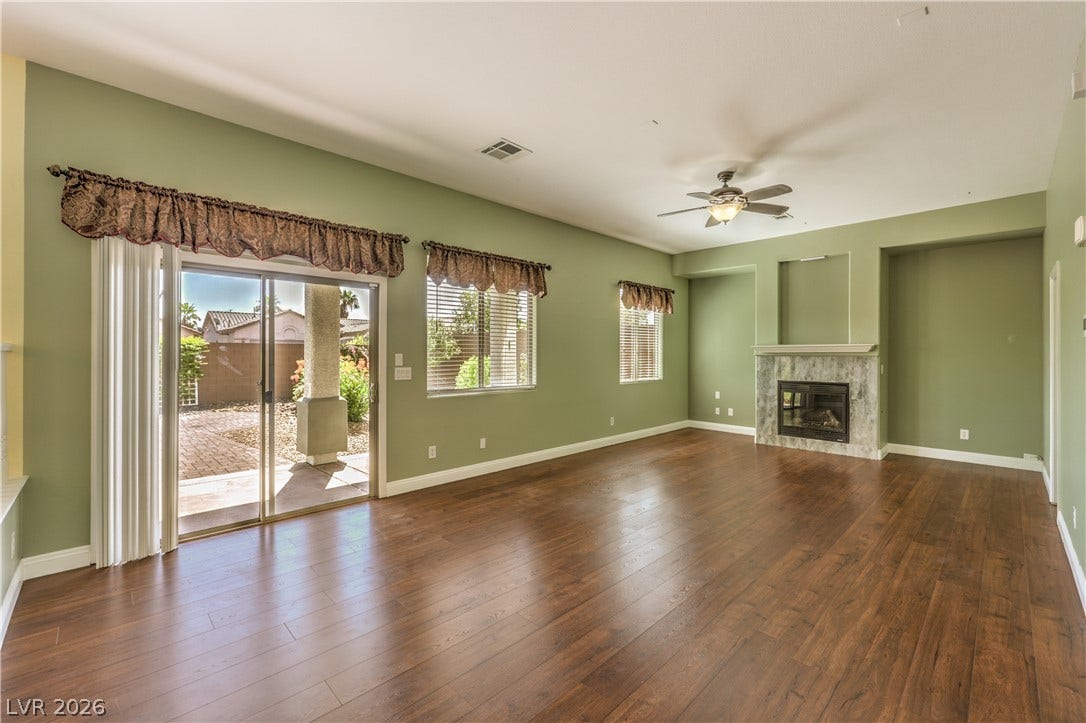 260 Quail Ranch Drive, Henderson, NV 89015 Rich hardwood floors extend through this ample living space, featuring a cozy fireplace and direct patio access.