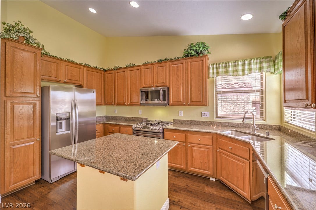 260 Quail Ranch Drive, Henderson, NV 89015 A well-appointed kitchen features warm wooden cabinetry and gleaming granite countertops, offering a central island for culinary endeavors.