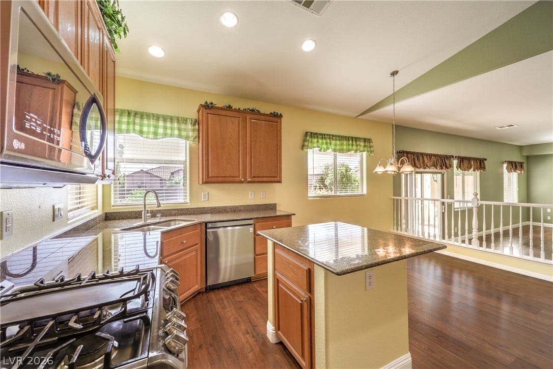 260 Quail Ranch Drive, Henderson, NV 89015 A well-appointed kitchen features stainless steel appliances, granite countertops, and rich wood flooring.