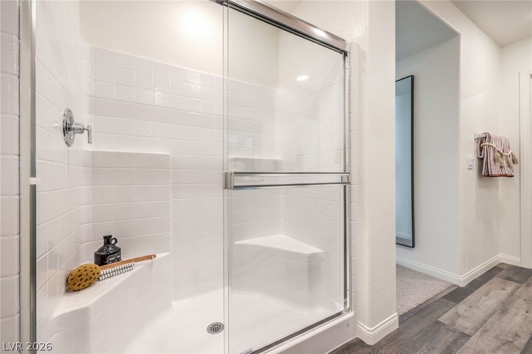 1030 PEACOCK PLUME Avenue, Henderson, NV 89011 Full bath featuring wood finished floors, a shower stall, and baseboards. Photo is representational only; actual home finishes may vary.
