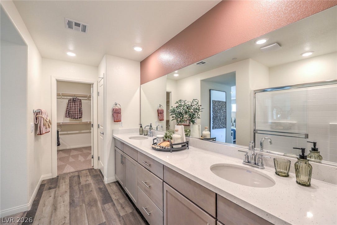 1030 PEACOCK PLUME Avenue, Henderson, NV 89011 Bathroom with wood finished floors, a spacious closet, double vanity, a shower with door, and recessed lighting. Photo is representational only; actual home finishes may vary.